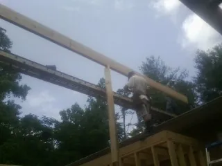 Carpenter setting a ridge beam over a new addition frame — Ice Dam Removal by Roofing Brothers in Princeton Junction