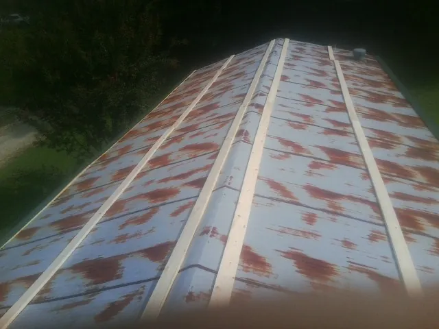 Rusted metal roof panels with new wood purlins before replacement — Storm Damage Roof Repair in Princeton Junction by Roofing Brothers