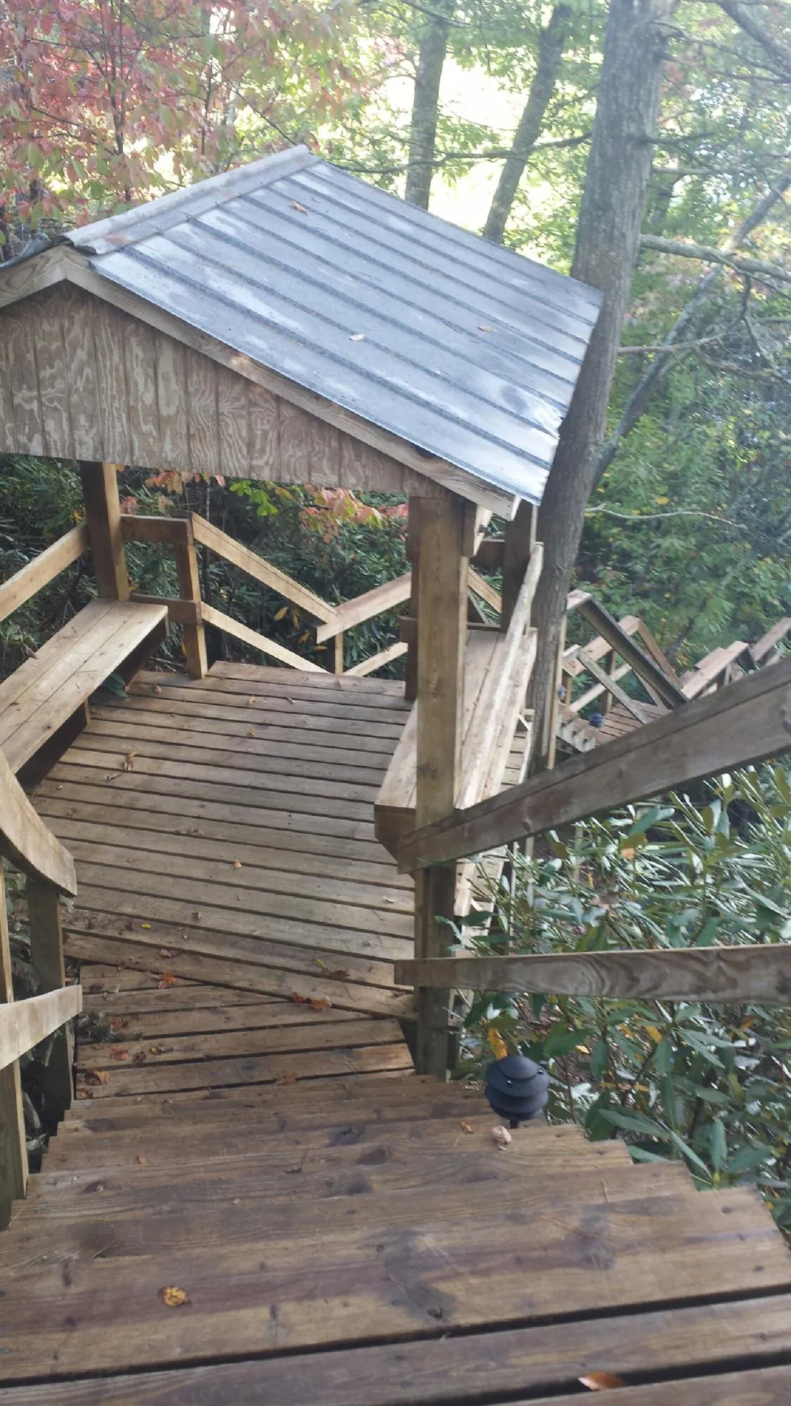 Metal roofed shelter over wooden steps on a wooded walkway — Skylight Repair & Installation work by our crew in Princeton Junction